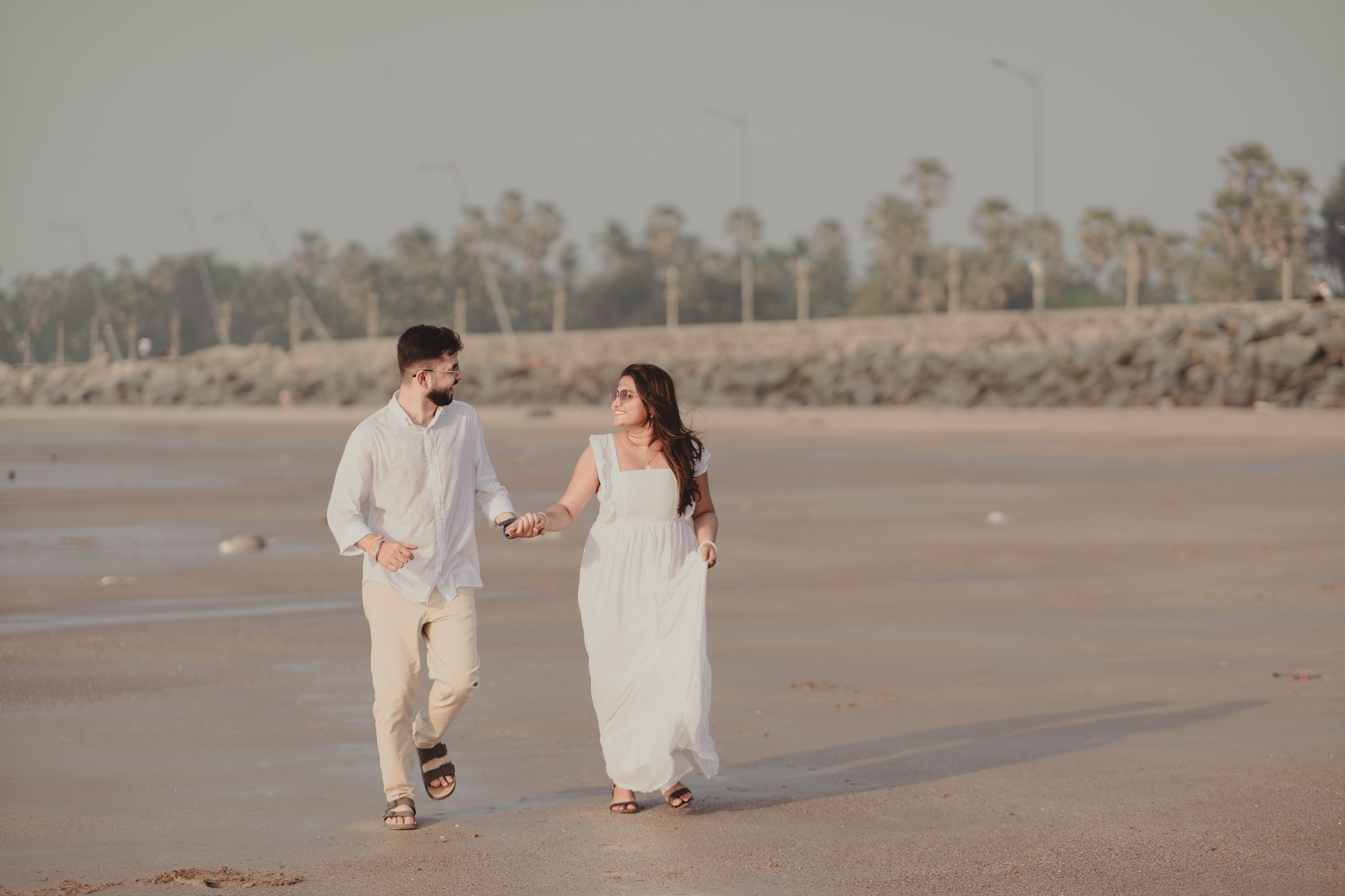 A couple in white on the beach at golden hour, photograph 05
