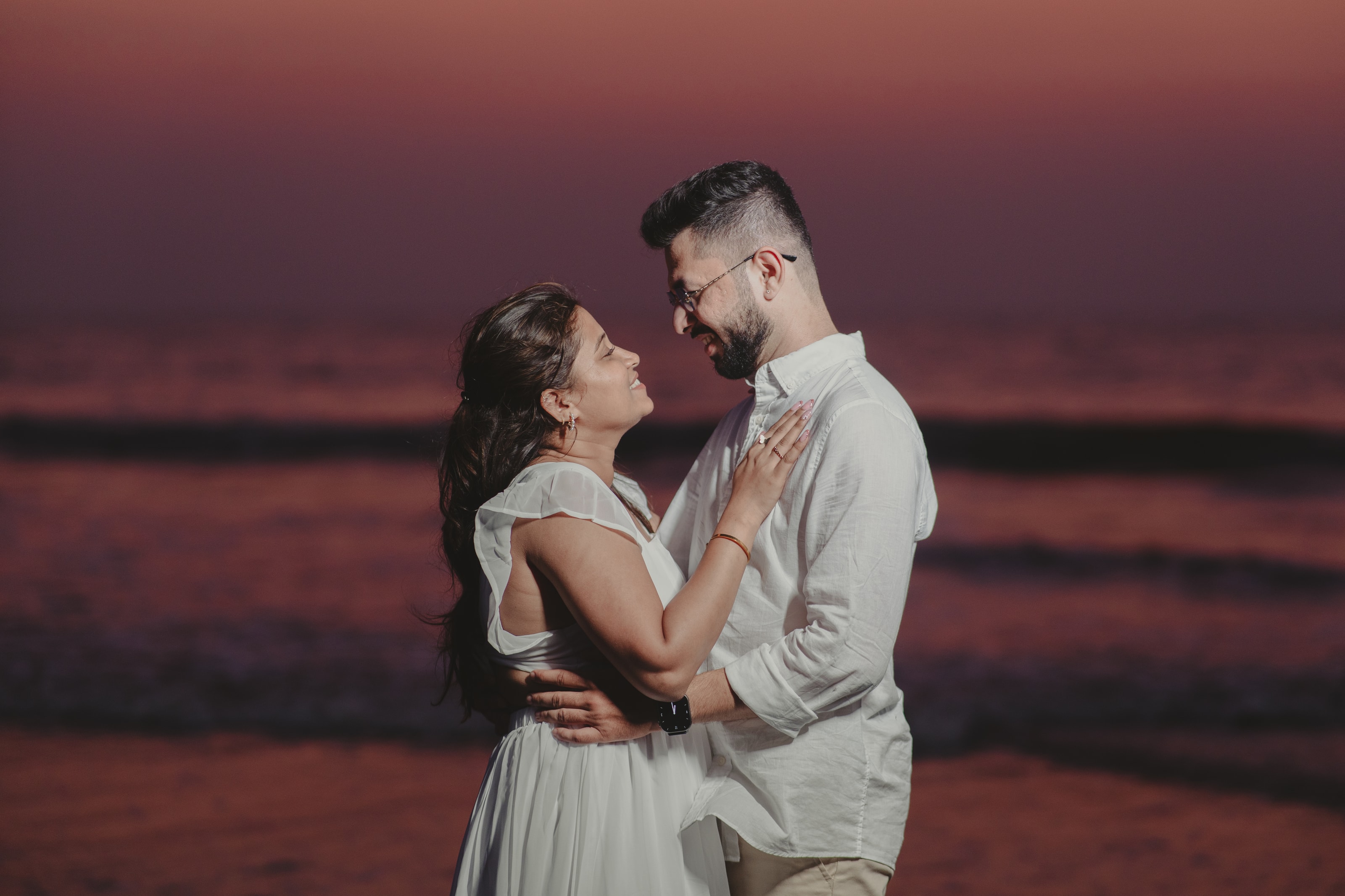A couple embracing against a red sunset, photograph 01